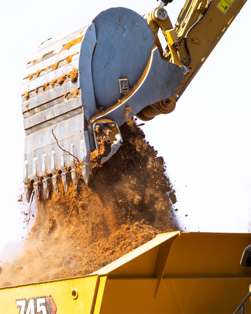 Excavator pouring dirt on a hauling truck